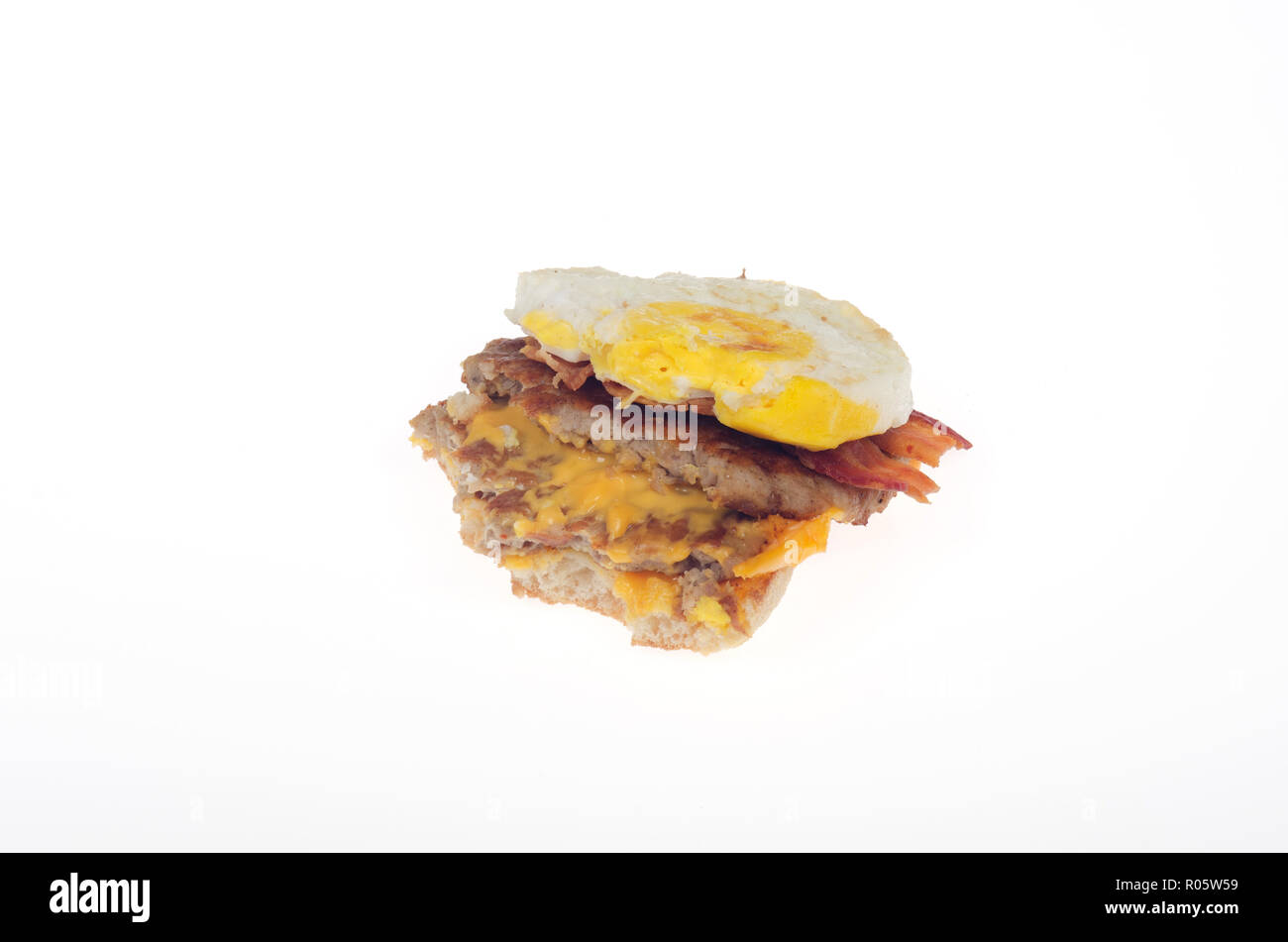 Top entfernt teilweise Ei, Würstchen, Speck und Käse McDonalds Triple Stack Breakfast Sandwich gegessen Stockfoto