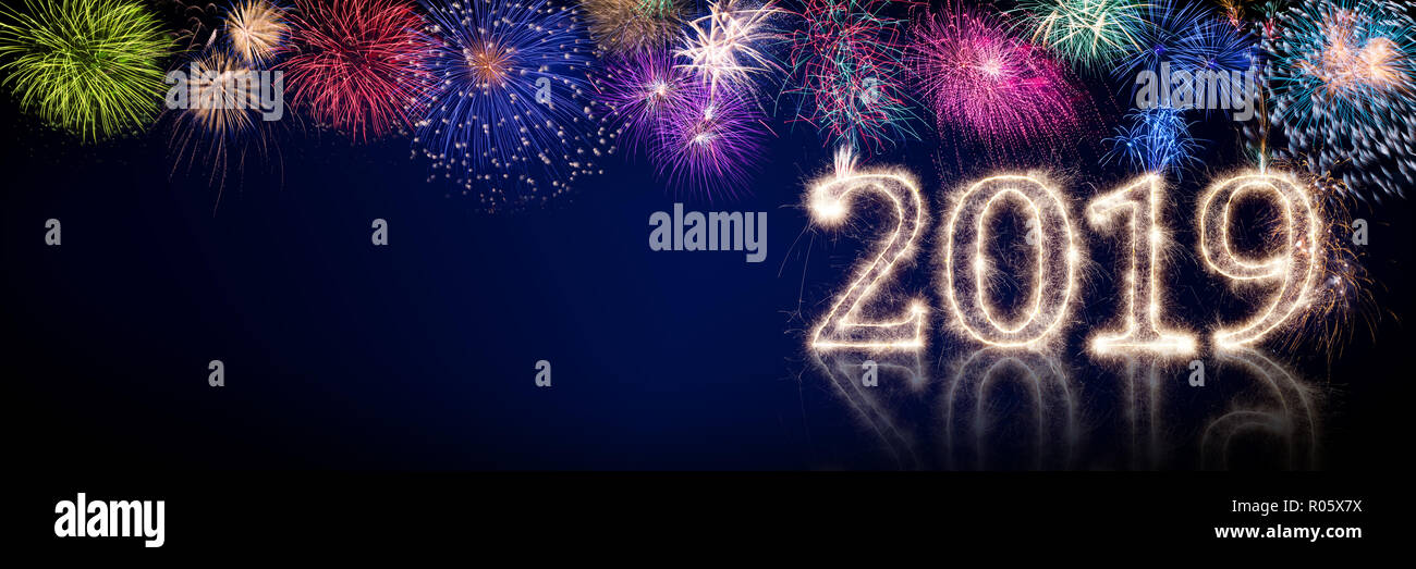 Buntes Feuerwerk und hellen Sparkler pyrotechnischen Anzahl 2019 Frohes neues Jahr Sylvester Konzept auf Schwarz Blau panorama Hintergrund Stockfoto