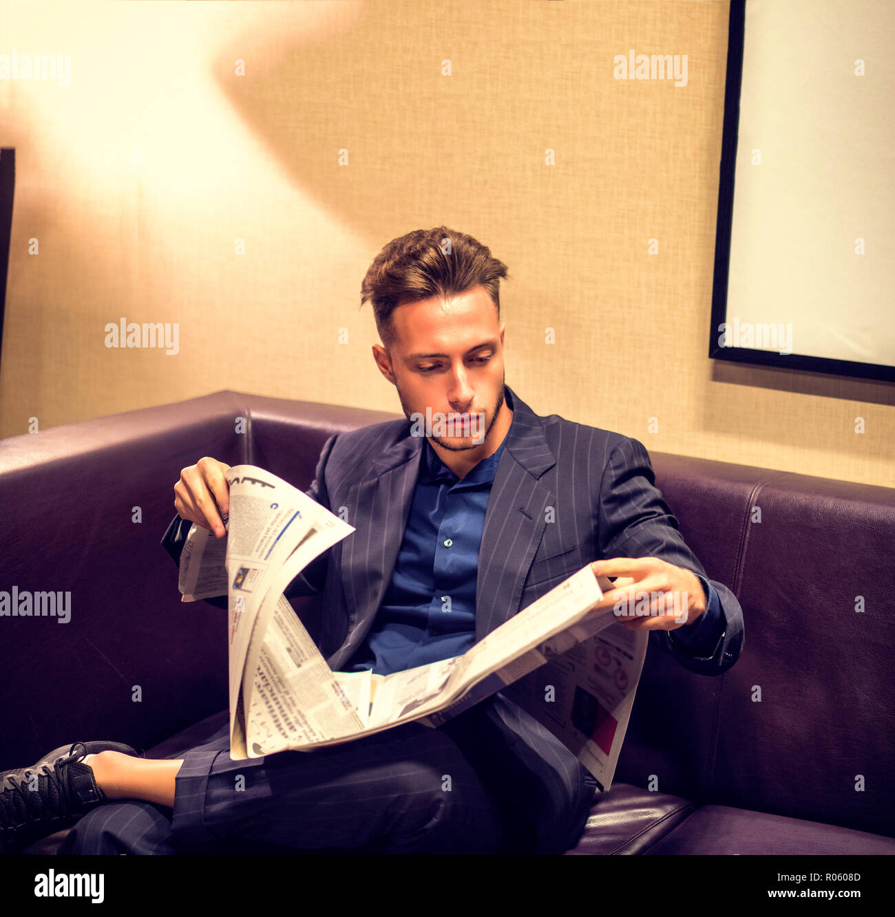 Hübscher junger Mann zu Hause lesen Zeitung Stockfoto