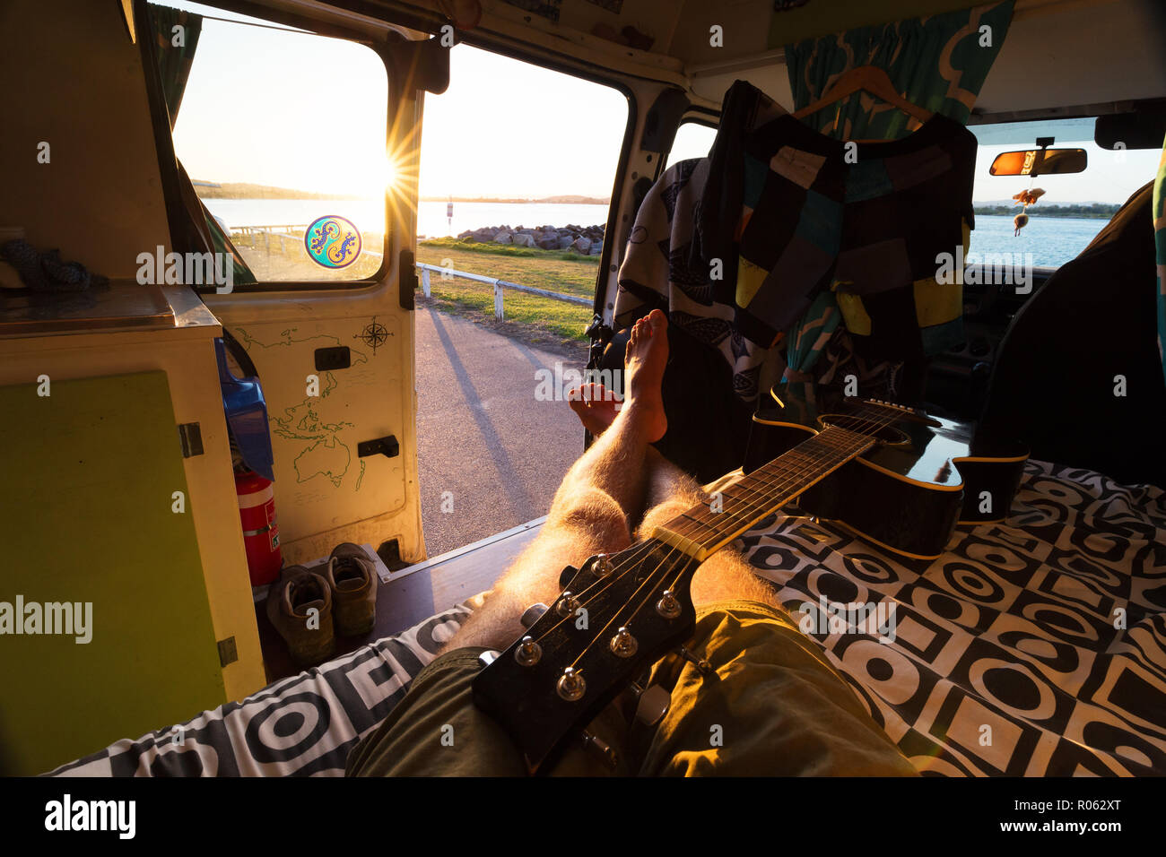 Sicht entspannt Mann in Van leben Wohnmobil Thema mit Gitarre und Sonnenuntergang Stockfoto