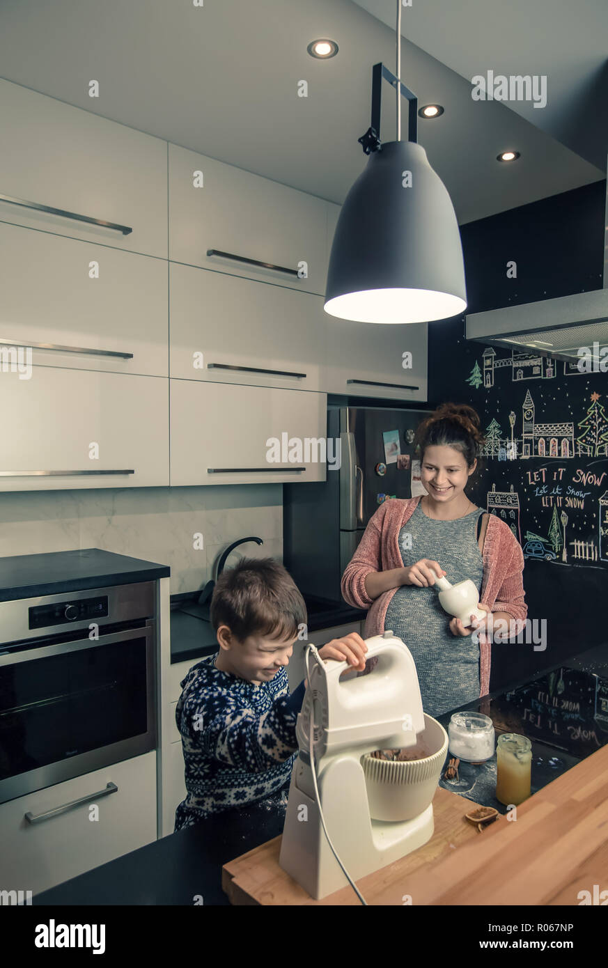 Glücklich liebende Familie in der Küche. Mutter und Kind bereitet den Teig, Backen Sie Plätzchen Stockfoto