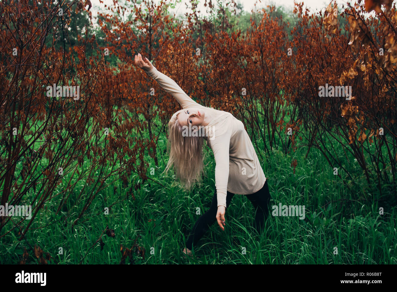 Porträt der jungen Mädchen tanzen zwischen toten Bäumen, in Bewegung Stockfoto