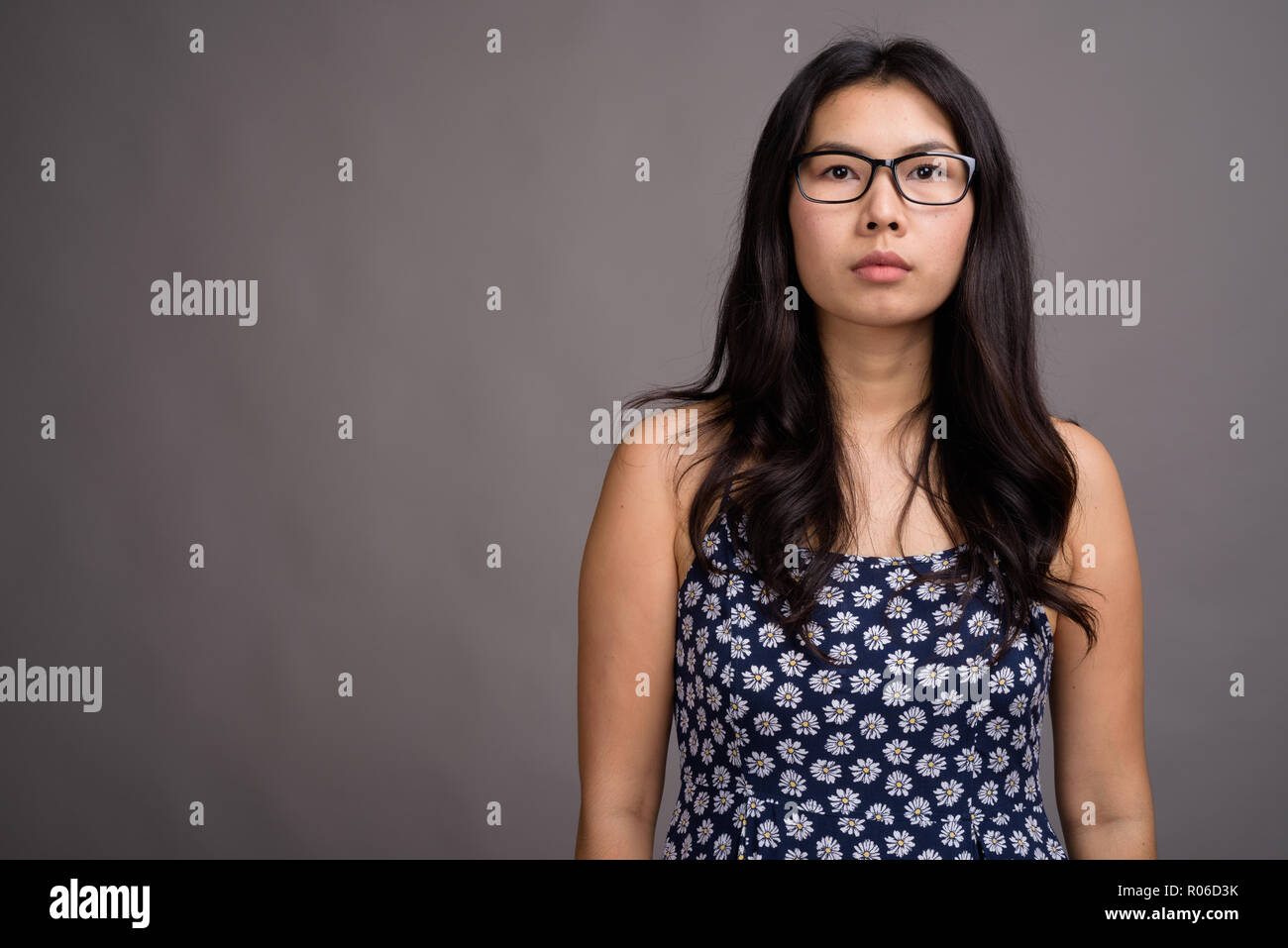 Asiatische Frau tragen Brillen gegen grauer Hintergrund Stockfoto