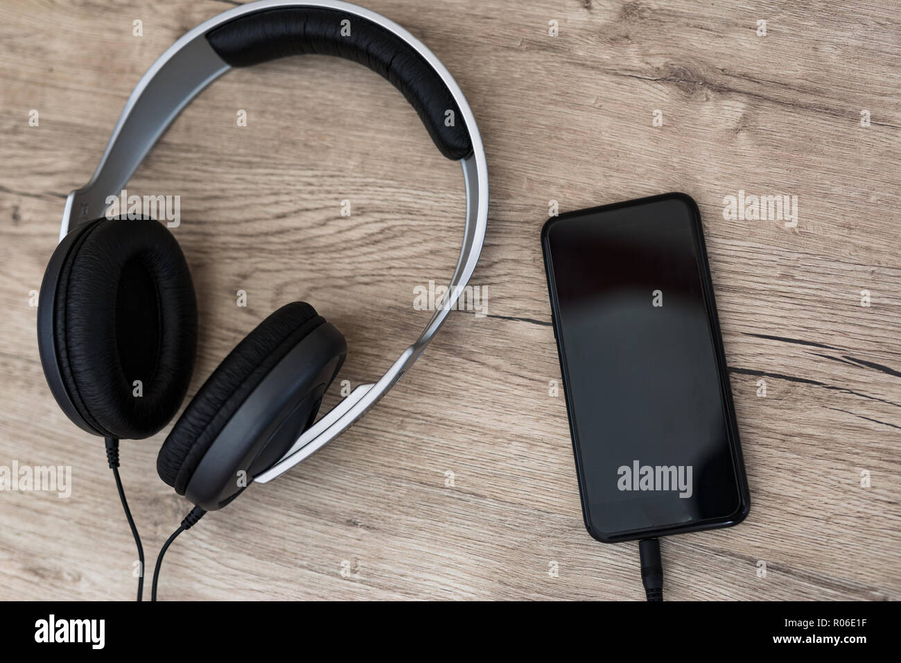 Mit Kopfhörern auf alten Holztisch Smartphone. Moderne Technologie Musik Player. Stockfoto