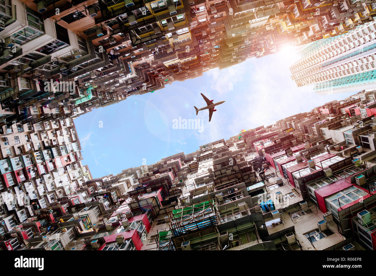 Ebene dramatisch flying Overhead in Hong Kong's Old dicht Wohnungsbau Bezirk von Quarry Bay mit absichtlichen Lens Flare. Stockfoto