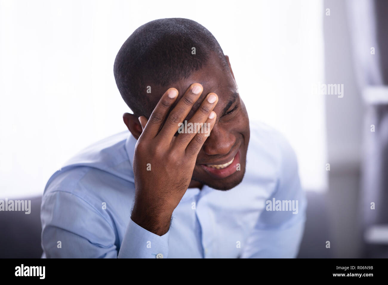 Nahaufnahme einer jungen afrikanischen Mann in Schmerz hielt seinen Kopf Stockfoto