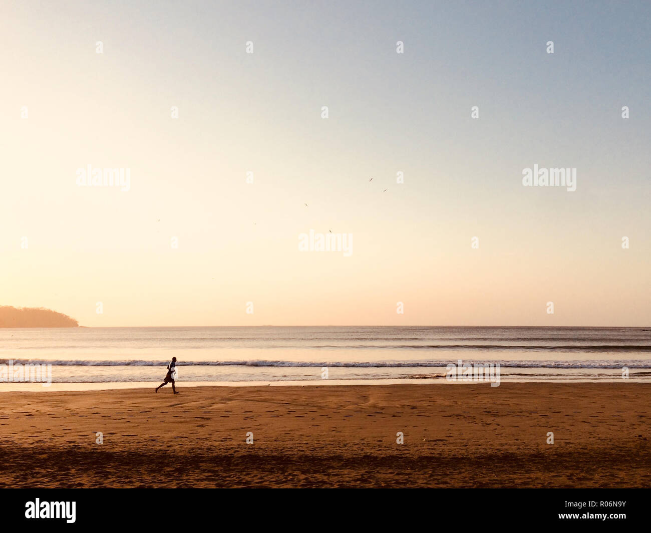 Person, am Strand bei Sonnenuntergang - Jogger im Ocean - Stockfoto