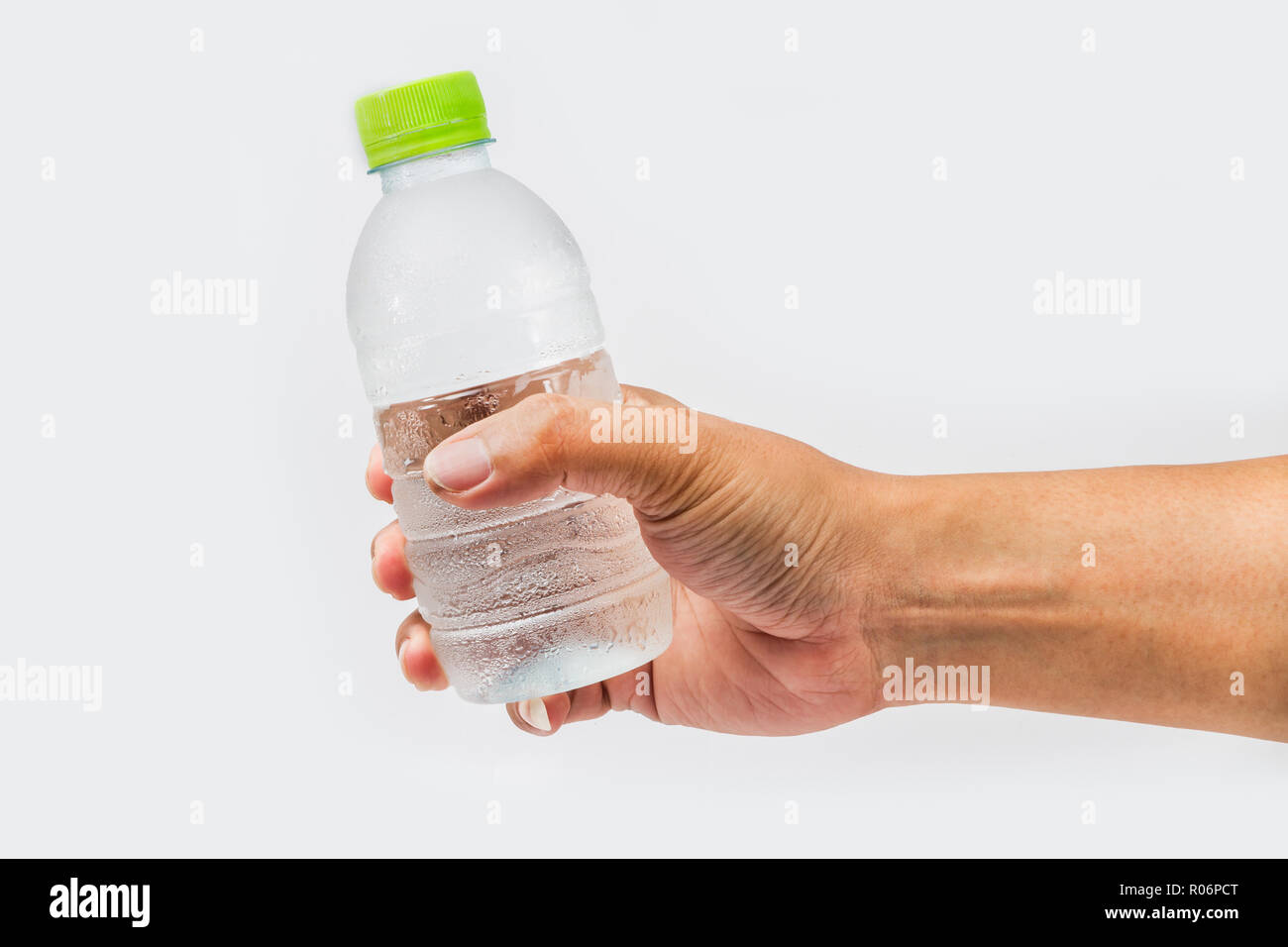 Trinkwasser Flasche in der Hand auf weißem Hintergrund Stockfoto