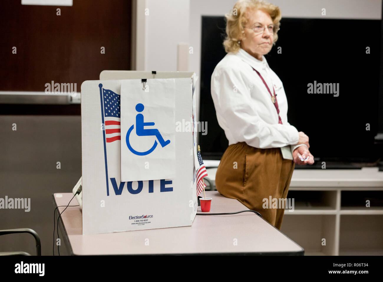 Ein Abstimmungarbeiter (Wahl Offizielle) erwartet jeder Behinderte Wähler - Virginia USA zu unterstützen. Stockfoto