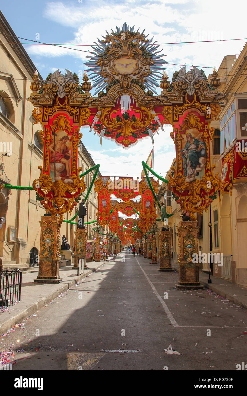 Fast leer, festlich geschmückten Straße mit alten traditionellen Balkonen. Tunnel der Banner und Statuen für jährliche Festa religiösen Urlaub im sonnigen Tag Stockfoto
