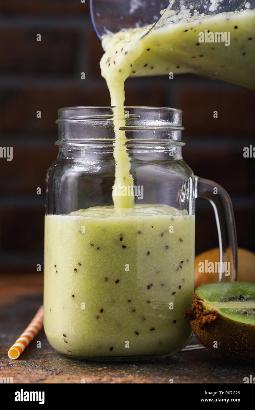 Prozess der Gießen frisch zubereitete Smoothies von Kiwi in einem Glas Stockfoto