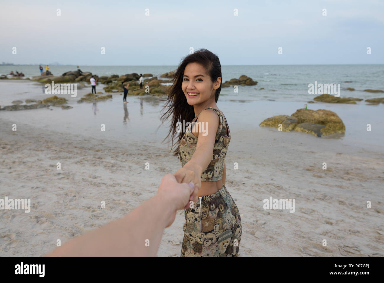 Junge glücklich schöne asiatische Frau lächelnd, während Hände halten ein Stockfoto