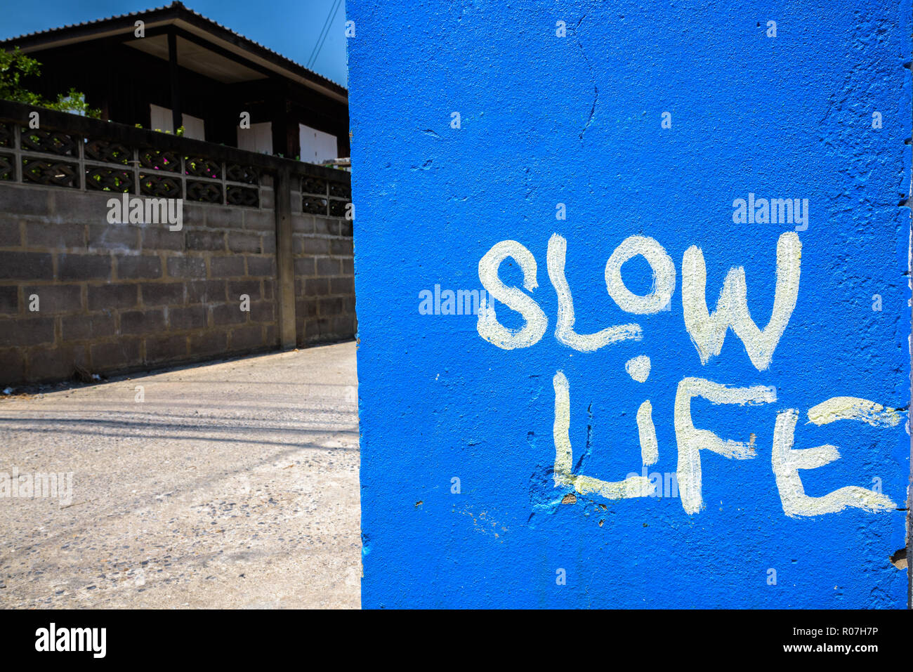 Blau lackiert mit Slow Life Text an der Wand geschrieben Stockfoto