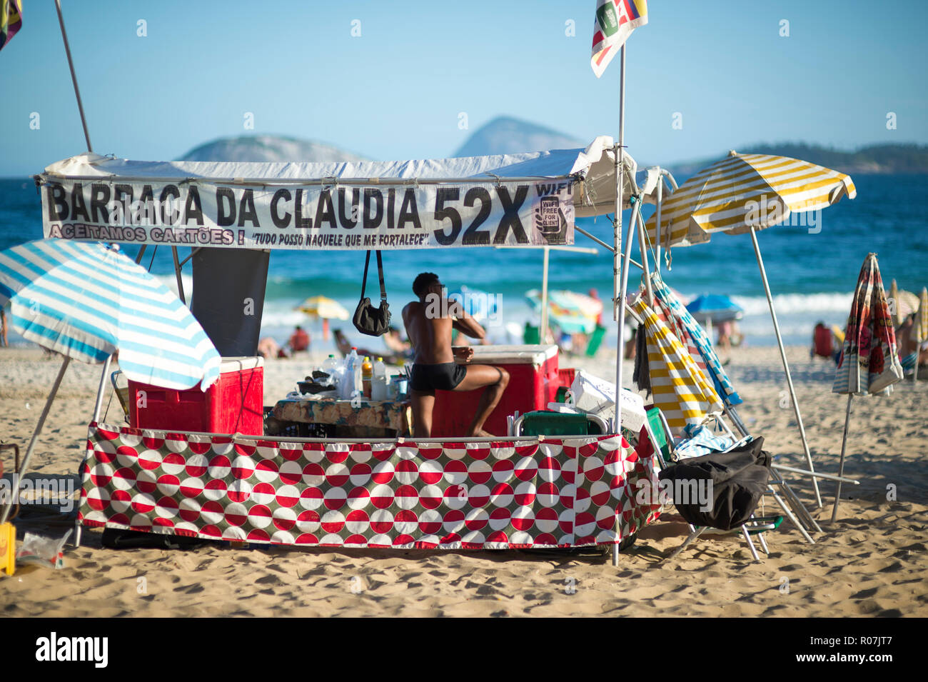 RIO DE JANEIRO - ca. Februar, 2018: Ein junger Mann verstand ein Beach Shack, einer der Vielen, die Getränke, Stühle und Sonnenschirme strandbesuchern am Ipanema Stockfoto