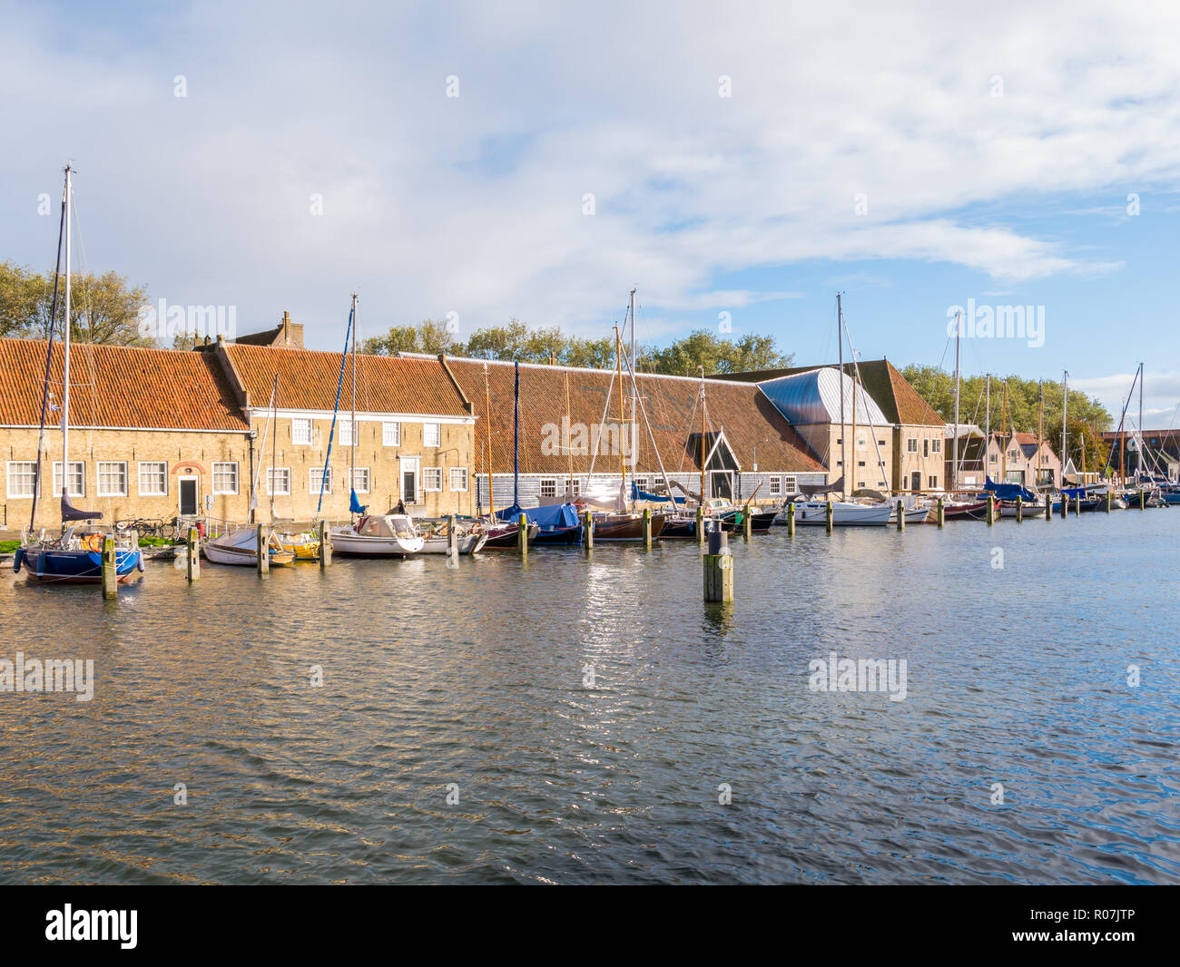 Reihe von Lagerhallen und Boote in Ost Hafen der historischen Altstadt von Enkhuizen, Noord-Holland, Niederlande Stockfoto