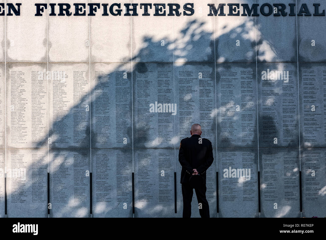 Feuerwehrmann spiegelt auf verloren gegangenen Kollegen an der New Yorker Feuerwehrmänner Memorial, Albamy, New York, USA. Stockfoto
