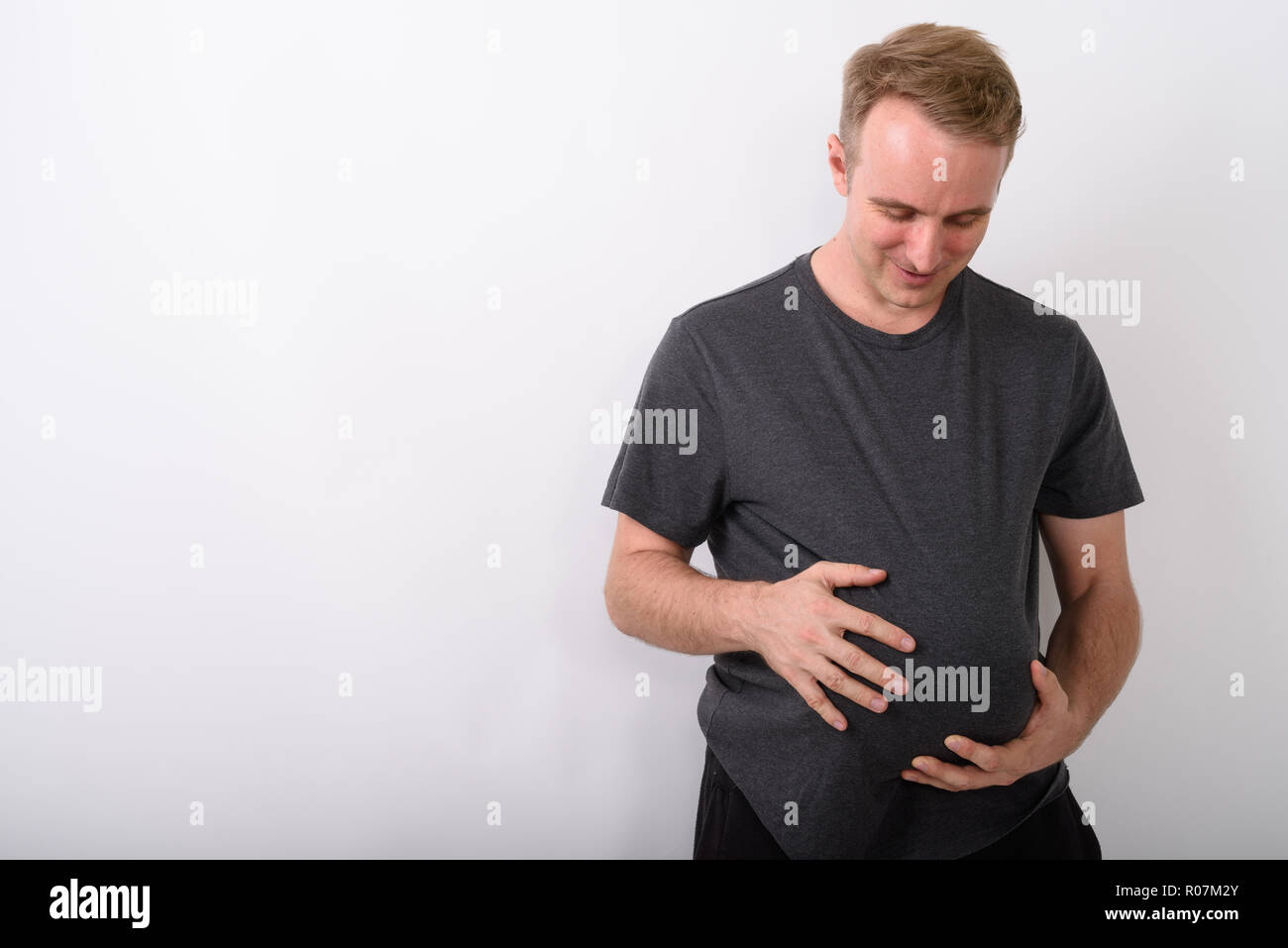 Der Mensch seinen Magen wie würde er schwanger sein und Erwarten baby Holding Stockfoto