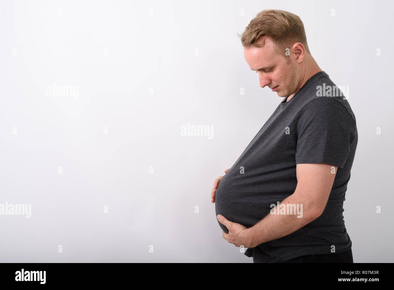Der Mensch seinen Magen wie würde er schwanger sein und Erwarten baby Holding Stockfoto