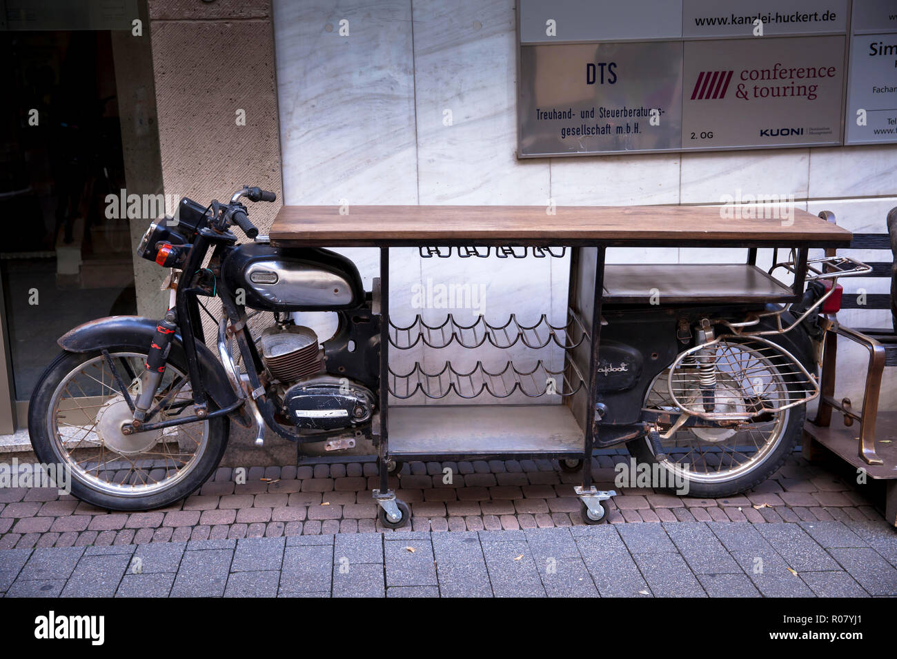 Ein altes Motorrad zu einer Bar Tisch mit flaschenhalterung, Köln