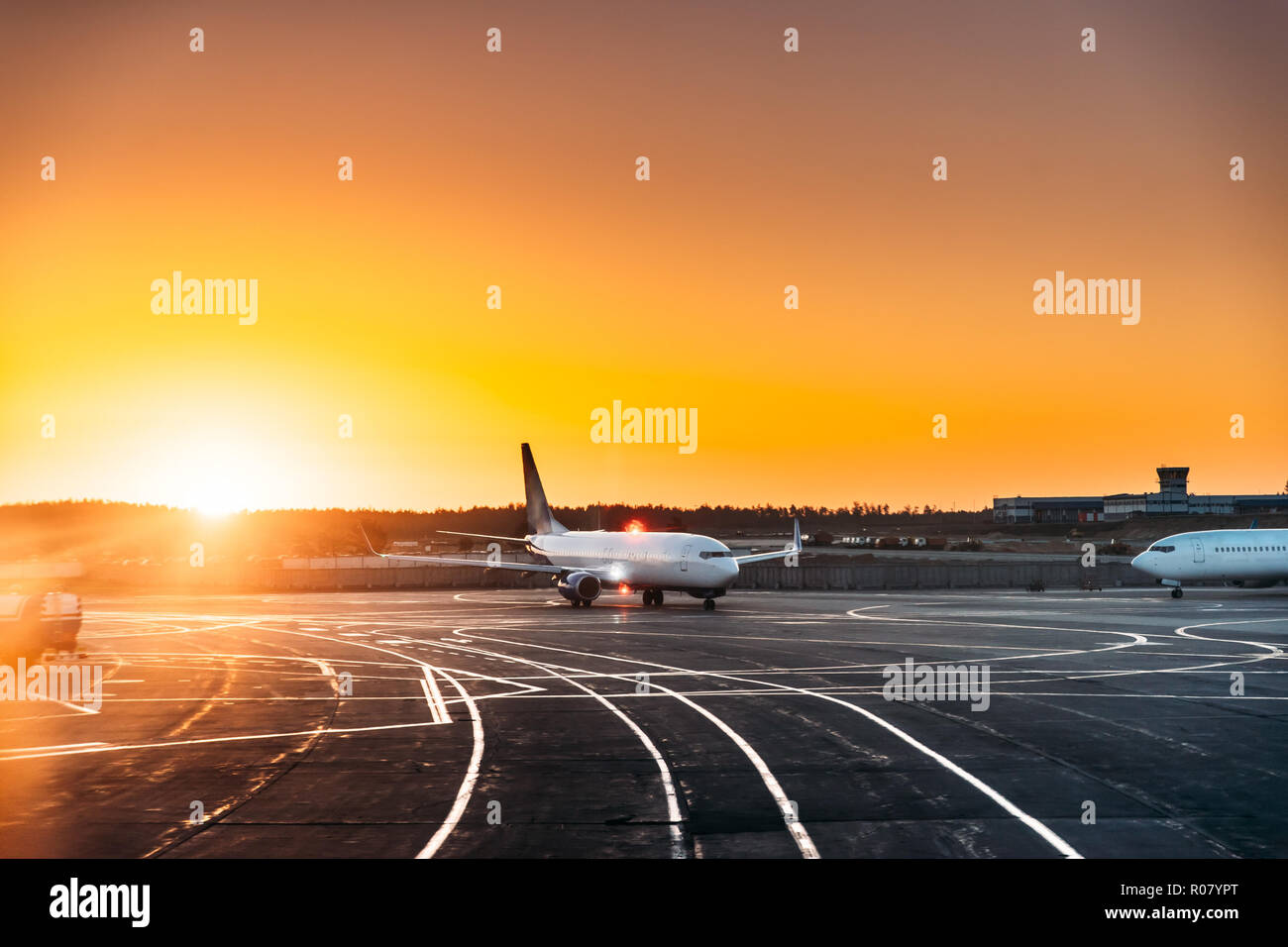 Flugzeuge Flugzeug Parken am Flughafen während der sonnigen Sonnenuntergang Sonnenaufgang. Stockfoto
