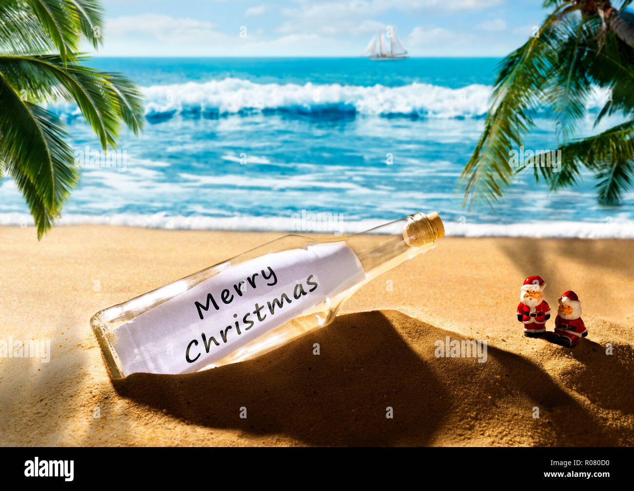 Flasche mit der Nachricht Frohe Weihnachten an einem herrlichen tropischen Strand Stockfoto