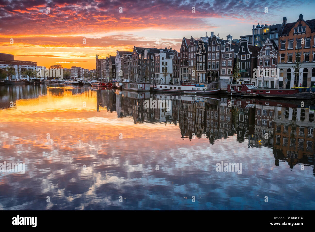 Amsterdam sunrise, Häusern und bunten Wolken waterreflection Stockfoto