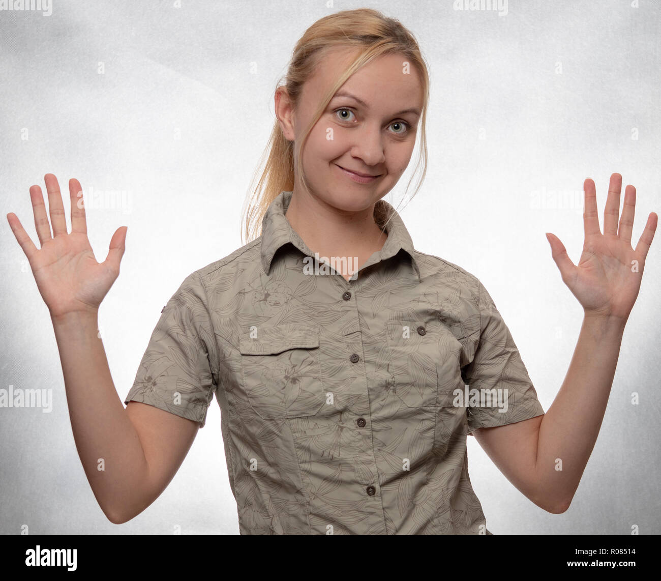 Junge Frau in trekking Hemd mit hands up Stockfoto