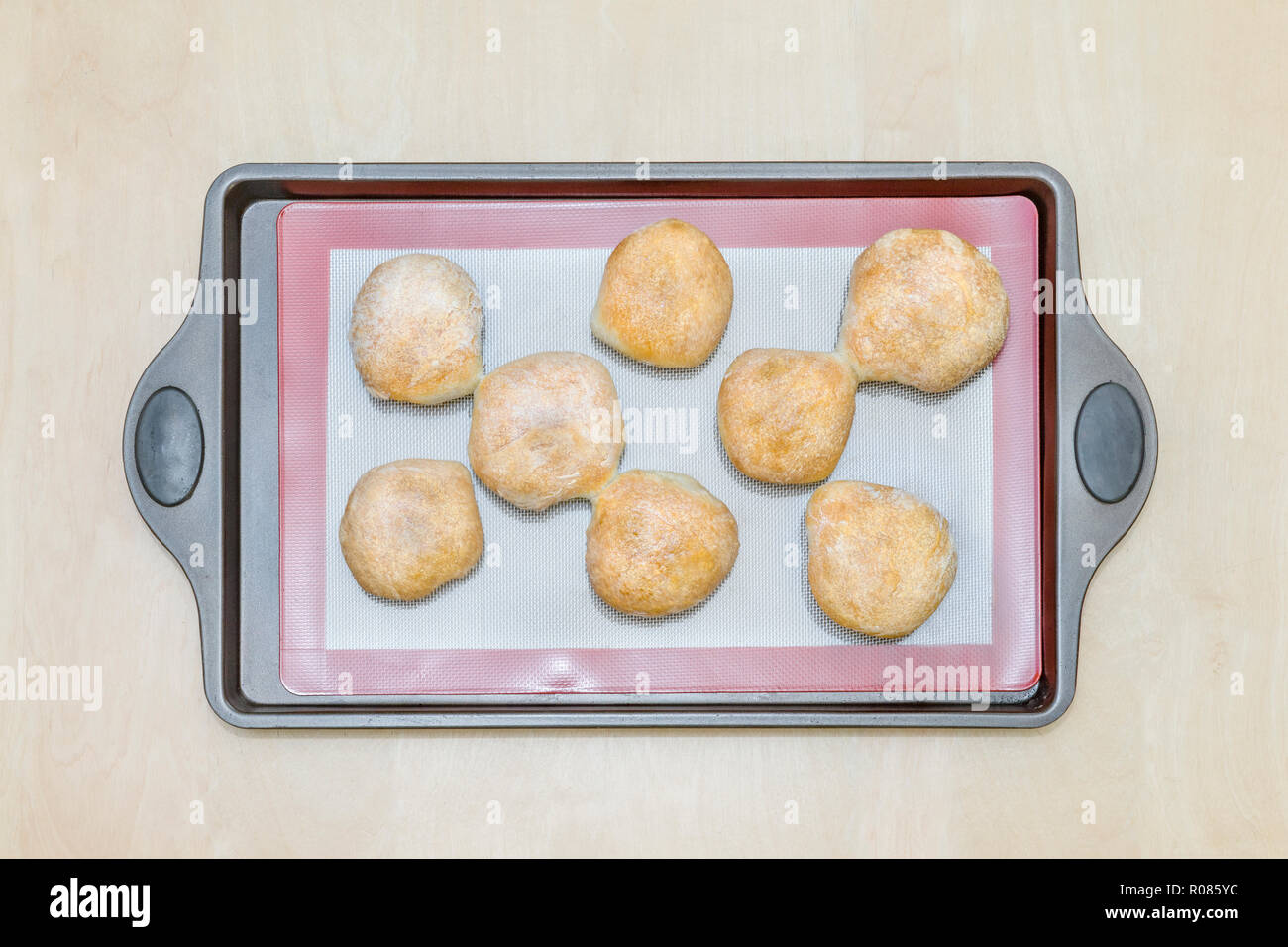 Frisch gebackene Brötchen auf einem Silikon backen Matte, auf einem eisernen Fach Stockfoto