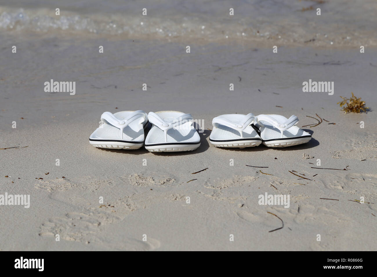 Weiße Sandalen am Strand. Stockfoto