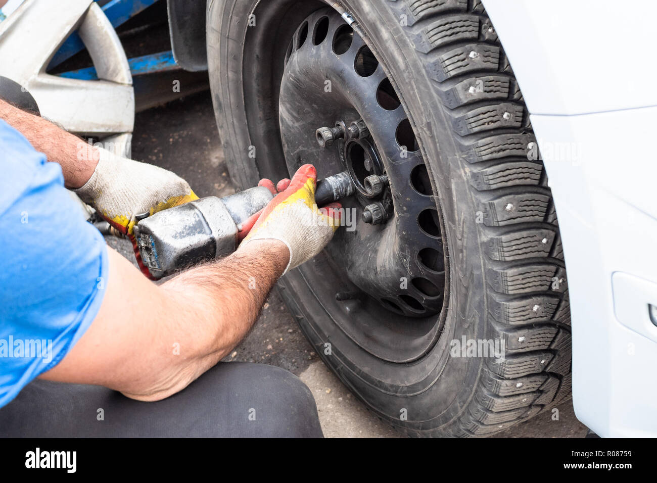 Techniker Schrauben ein Winter Auto Rad von pneumatischen