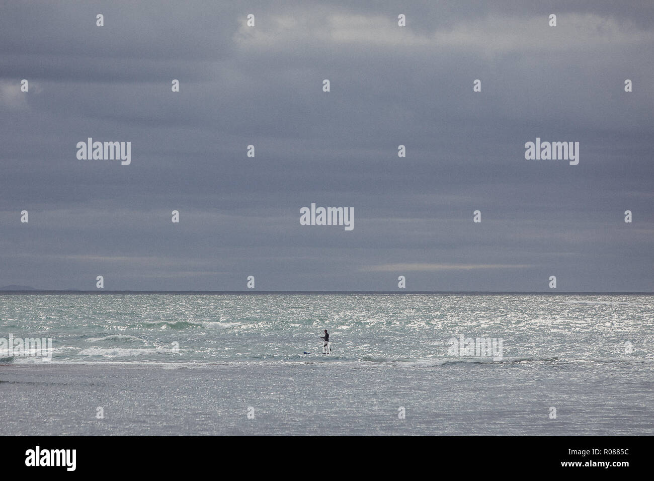 Person lernen Surfen in der Irischen See, vor der Küste von Anglesey, Rhosneigr, North Wales, UK Stockfoto