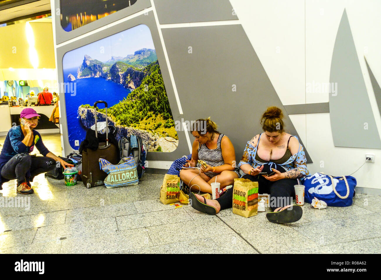 Palma de Mallorca Flughafen, drei Frauen essen, anrufen, Laden der Telefonleute warten auf dem Boden, Stress Spanien Tourismus Europa Stockfoto