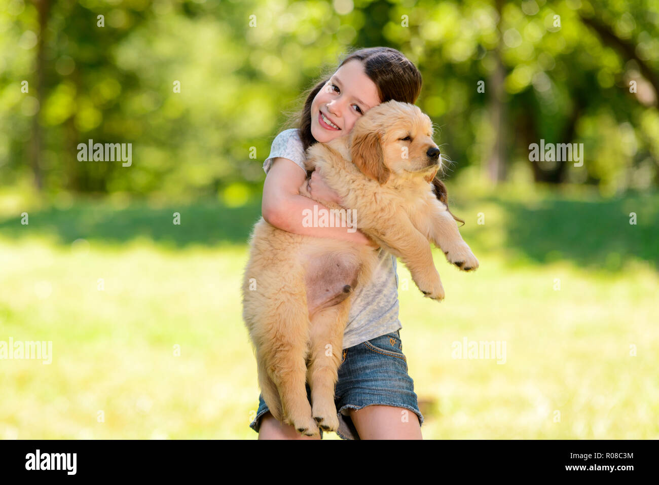 Kind umarmt einen Welpen Stockfoto