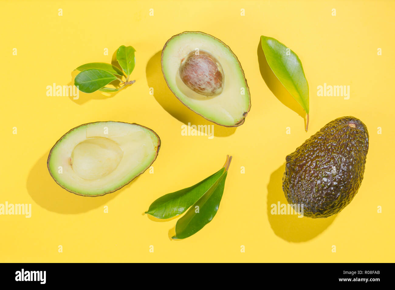 Scheiben Avocado auf weißem Hintergrund. Ganze und halbe mit Blättern. Design Element für Etikett, Ansicht von oben Stockfoto