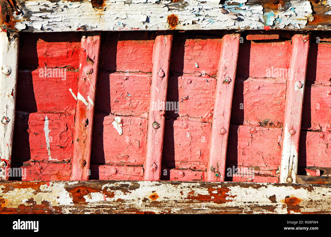 Eine Nahaufnahme der Innenraum eines alten Klinker gebaut Küstenfischerei Boot mit abblätternder Farbe bei Thornham, Norfolk, England, Vereinigtes Königreich, Europa. Stockfoto