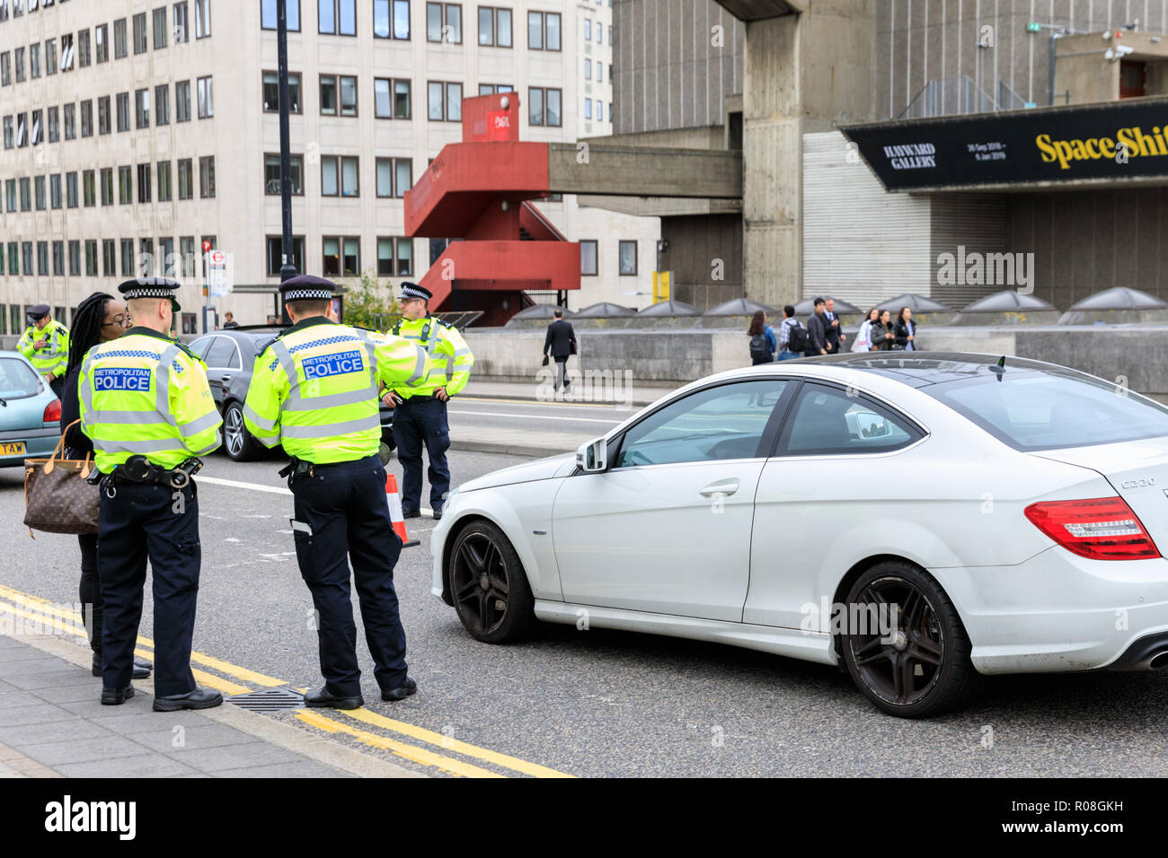 Metropolitan Police Officer stoppt Autos und spricht mit den Fahrern während einer Stopp-und Suchsicherheitsmaßnahme in Waterloo Bridge, London Stockfoto