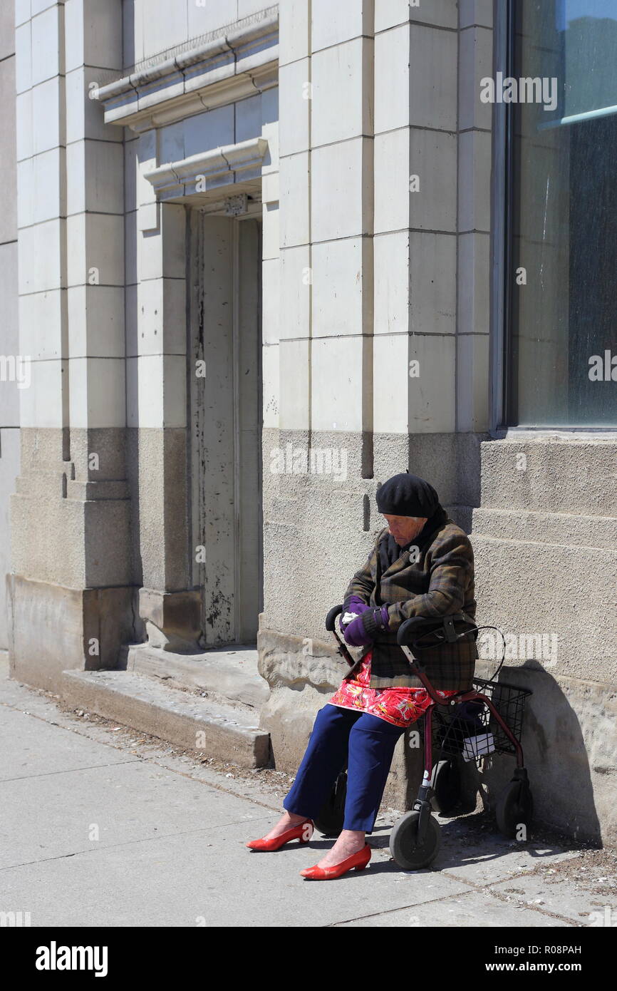 Eine ältere Frau hält ein Nickerchen auf einem kalten Tag, Downtown Toronto Stockfoto