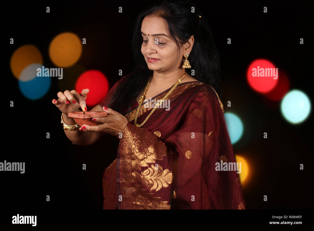 Eine Schone Indische Frau Besetzt Einstellen Der Flamme Des Traditionellen Lampe Wahrend Diwali Festival In Indien Auf Dem Hintergrund Der Blur Bunt Dekorativ Stockfotografie Alamy