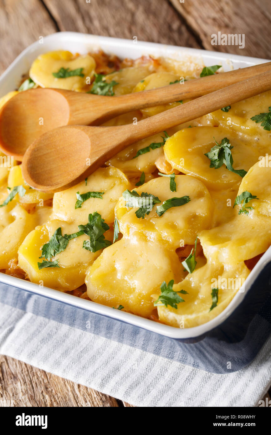 Baked Sauerkraut mit Kartoffeln, Speck und Käse Nahaufnahme in der auflaufform auf den Tisch. Deutsches Essen. Vertikale Stockfoto