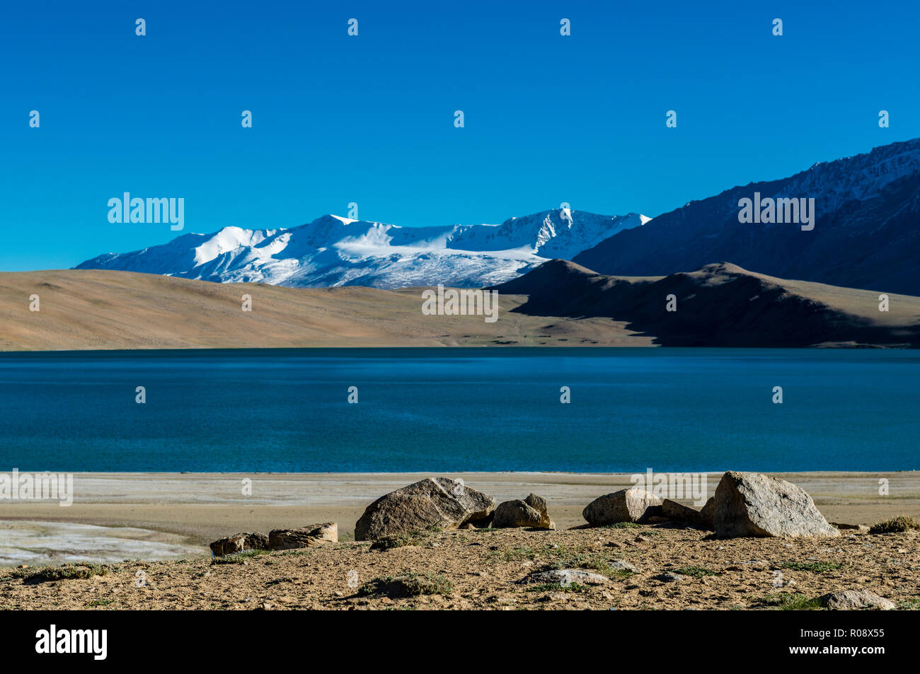 Schneebedeckte Berge, die sich hinter dem tiefblauen Wasser von Tso Moriri, 4,595 m über dem Meeresspiegel in Changtang Bereich befindet. Stockfoto