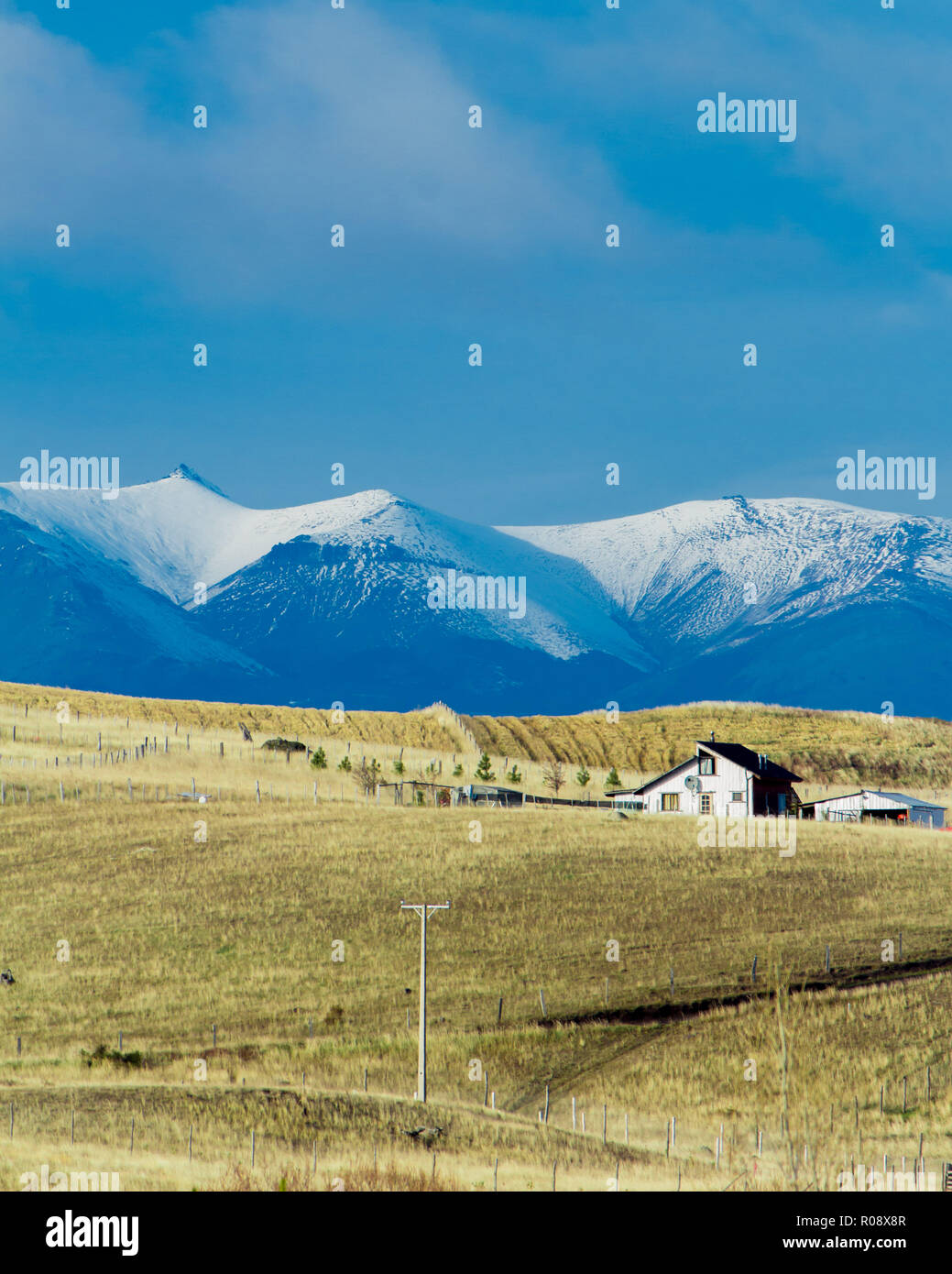 Einfaches Haus entlang der Carretera Austral route mit den Bergen der Anden im Hintergrund Stockfoto