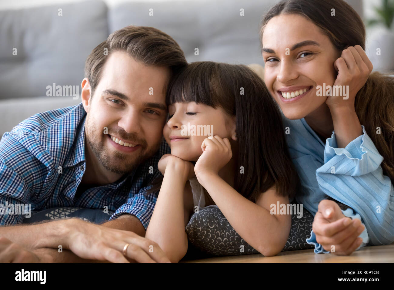 Schöne vielfältige Familie auf warmen Boden zu Hause liegen Stockfoto