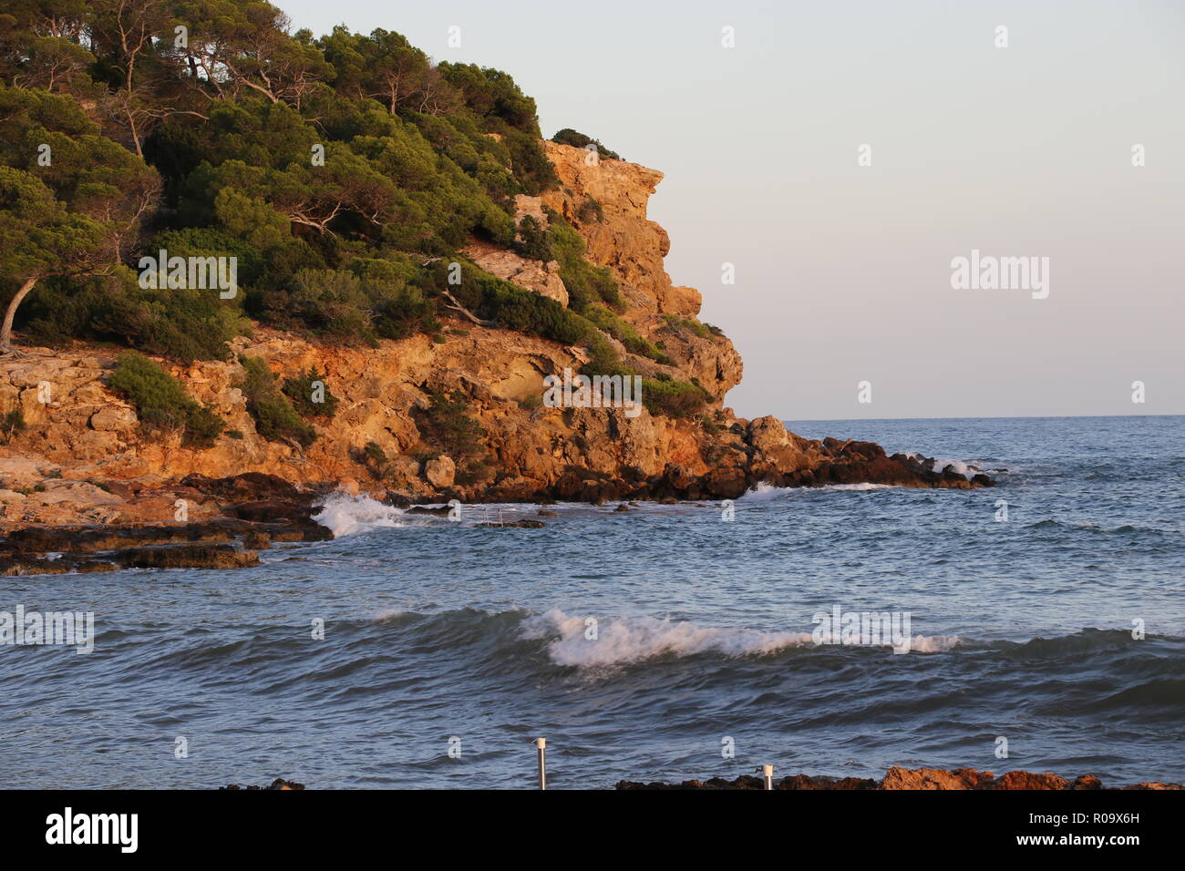 Wellen am Ufer eines felsigen Landzunge in Ibiza Stockfoto