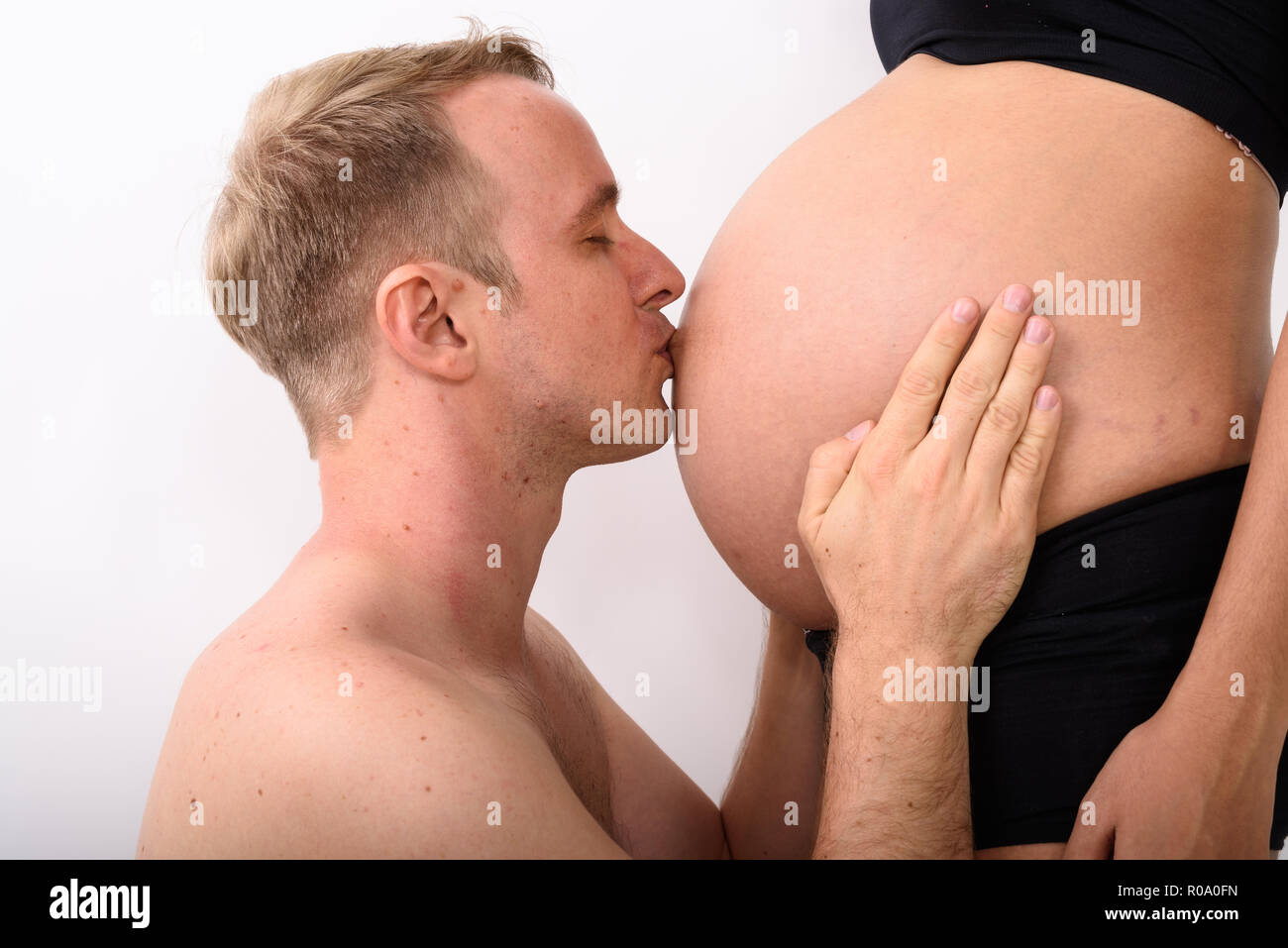 Mann küssen den Magen von seiner schwangeren Frau mit Magen Stockfoto