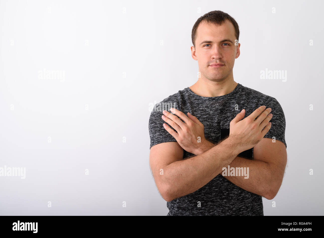 Studio shot Junger muskulöser Mann mit verschränkten Armen auf ches Stockfoto
