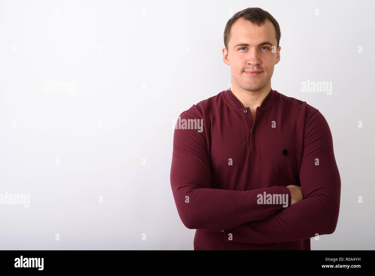 Studio shot Junger muskulöser Mann mit Waffen gegen whit gekreuzt Stockfoto