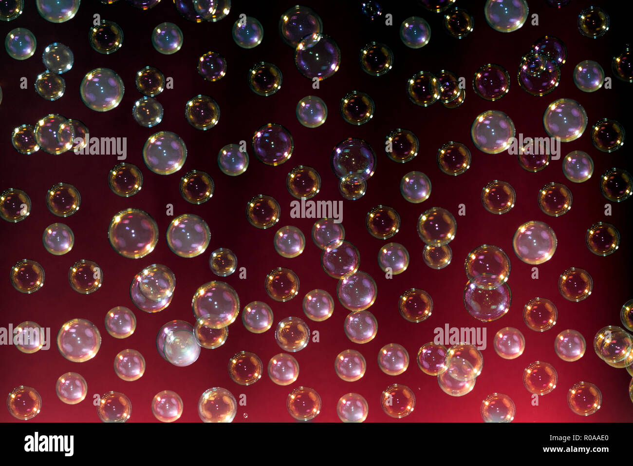 Seifenblasen mit Rauch auf dunklem Hintergrund rot Stockfoto