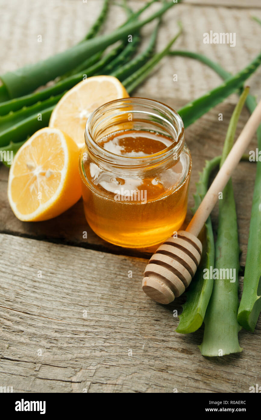 Home Spa hautpflegewirkstoffe. Gelber Honig im Glas und Zitrone, Aloe Vera, natürliche Schönheit Produkt closeup Stockfoto