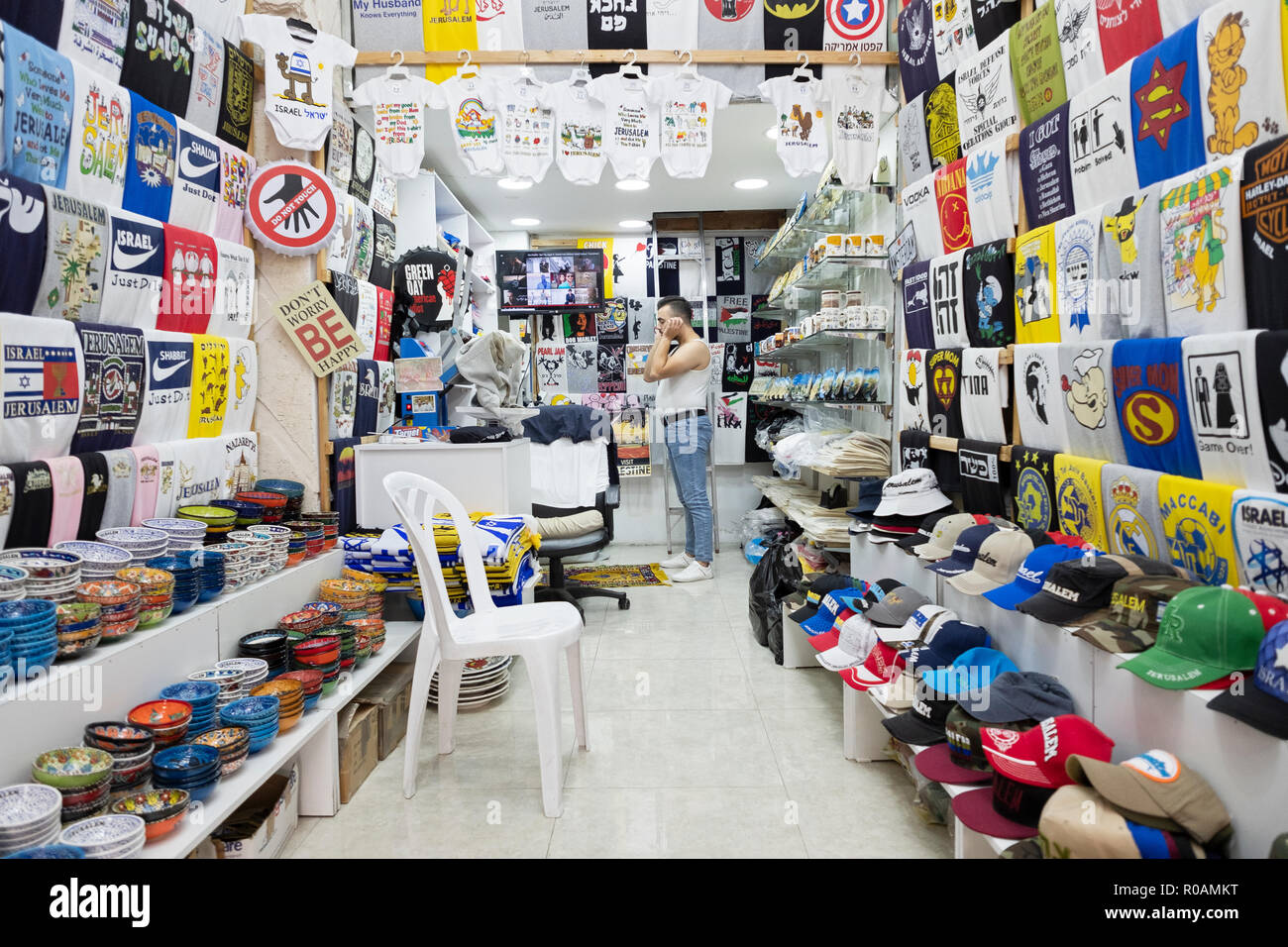 Ein arabischer Mann Betrieb ein Souvenir&t shirt Store in der Altstadt von Jerusalem, Pausen für die täglichen Gebete. Stockfoto
