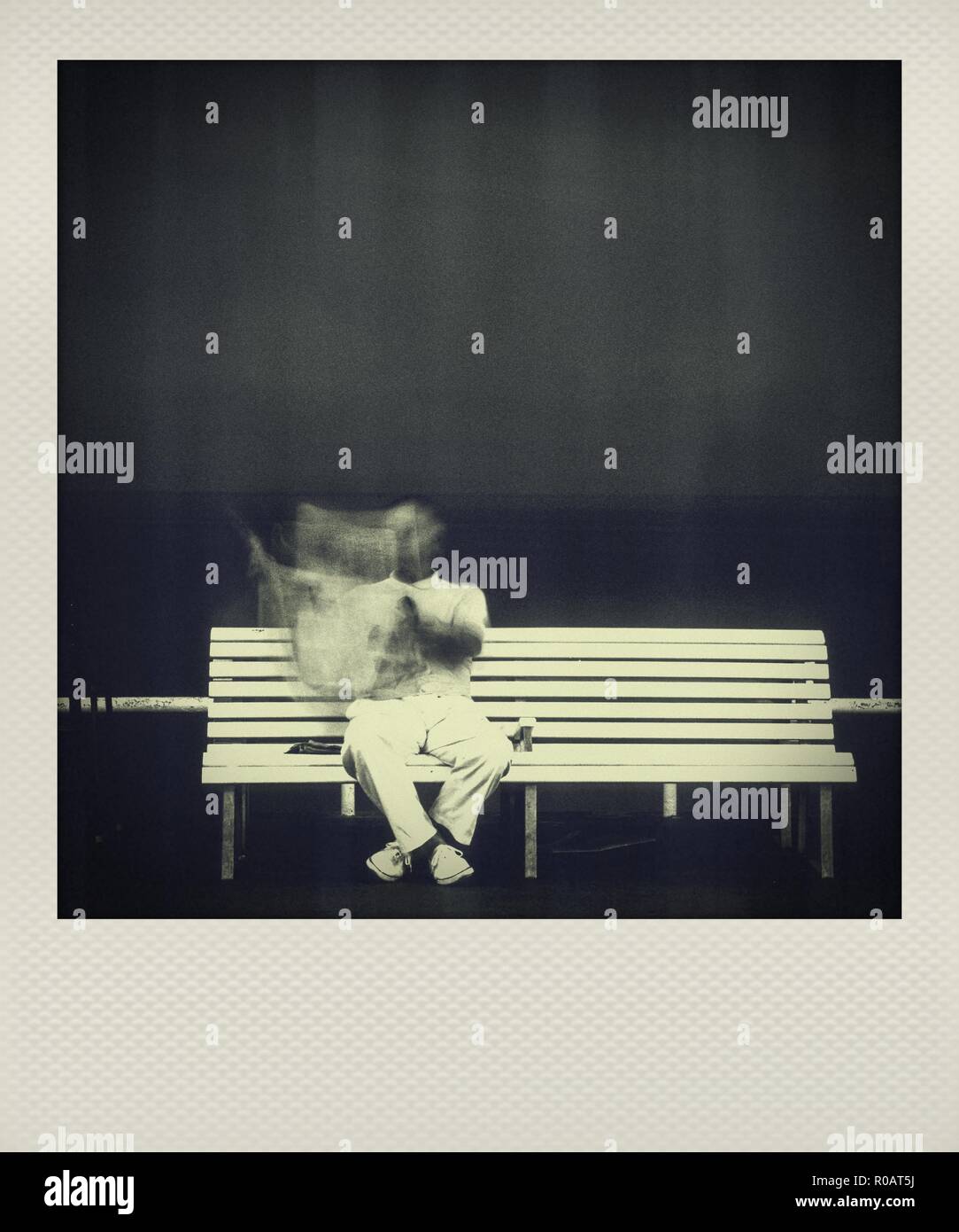 Polaroid lange Belichtung Foto von einem Mann auf einer Bank sitzen Stockfoto